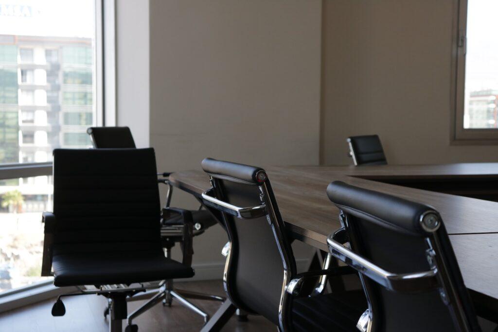 five black rolling chars front of desk